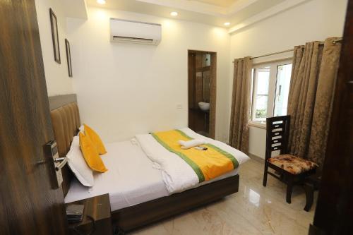 新德里Hotel Emporio Dx - New Delhi Railway Station - Paharganj的一间小卧室,配有一张床和一把椅子