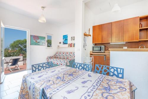 圣安德烈亚Villetta Sant'Andrea - Goelba的一间卧室配有一张床,厨房设有阳台