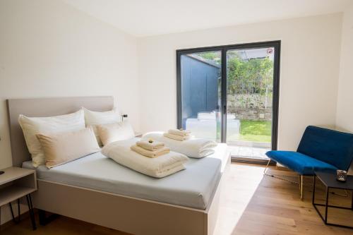 因斯布鲁克Moderne Wohnung mit Terrasse的一间卧室配有一张床和一张蓝色椅子