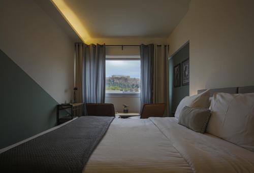 雅典Elite Ermou Suites的一间卧室设有一张大床和一个窗户。
