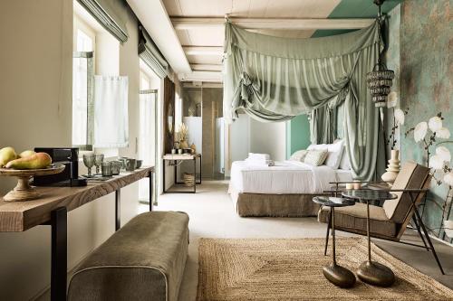 普拉卡米洛斯Niove Suites Milos的一间卧室配有一张床、一张沙发和一张桌子