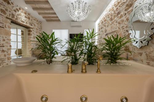 干尼亚il Campanile Luxury Living的一间带植物和吊灯浴缸的浴室