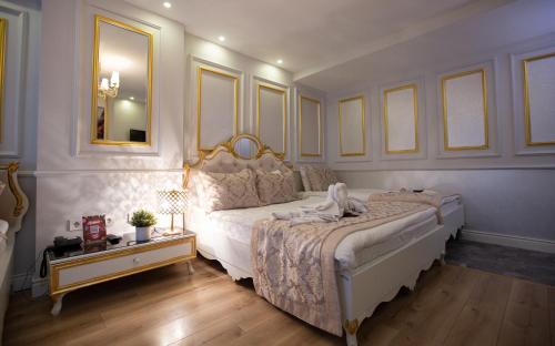 伊斯坦布尔Sirkeci Ersu Hotel & SPA的一间卧室配有一张大床和镜子