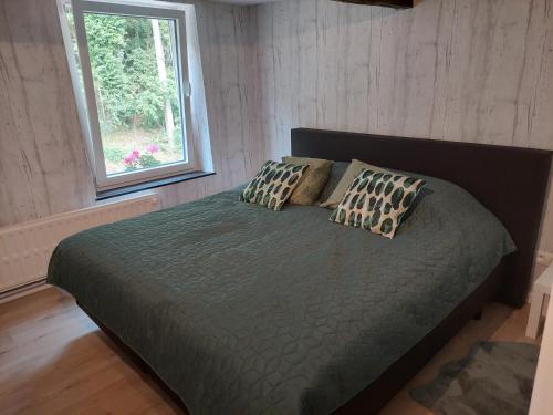 杜柏Au doux Chardon的一间卧室配有带两个枕头的床和窗户