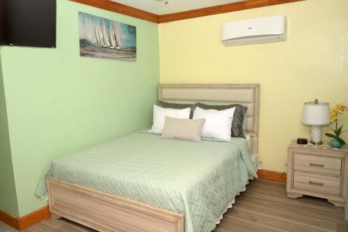 自由港市Cottage by Jubilee的一间卧室配有一张床和一个带灯的床头柜
