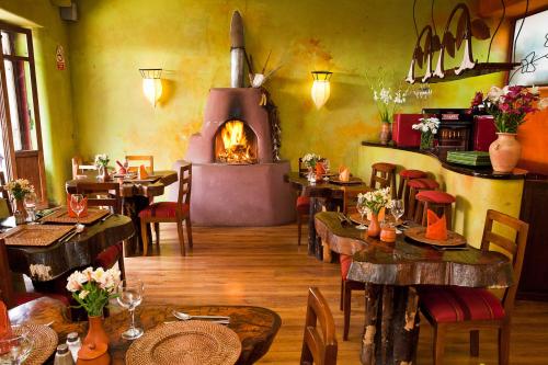皮萨克Pisac Inn的一间带桌子和燃木烤箱的餐厅