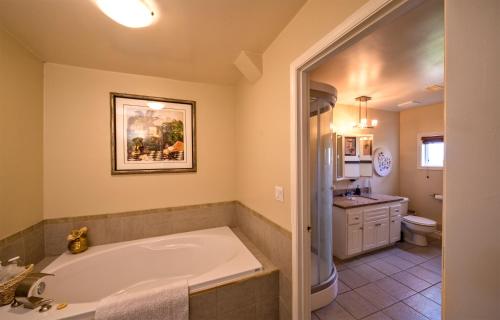 彭蒂克顿Above the Beach Guest Suites的带浴缸和盥洗盆的大浴室