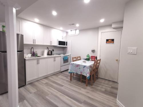 米西索加Perfect location comfort private house lower level 2 bedroom unit的厨房配有白色橱柜和桌椅