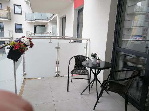 埃尔布隆格Apartament Mielczarskiego的阳台配有桌椅和桌子