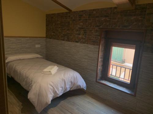 巴尔德韦德哈Pensión Valdeverdeja - Entorno Rural y Natural - Castilla La Mancha的一间卧室配有一张带镜子的床和窗户