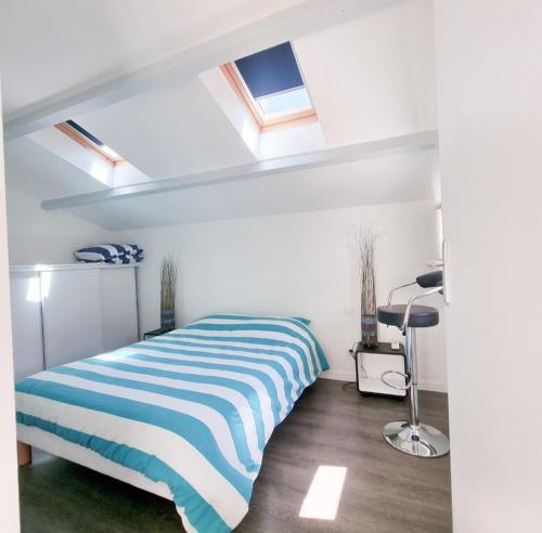 圣特罗让莱班La Belle Cordière的一间卧室配有一张带蓝白条纹毯子的床