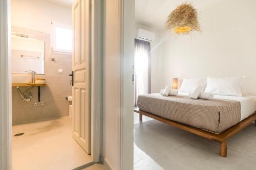 斯基亚索斯镇Dohos Skiathos Suites的一间白色卧室,配有床和一间浴室