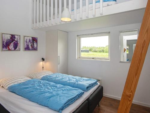 哈泽斯莱乌Holiday home Haderslev L的卧室内的一张带蓝色床单的床