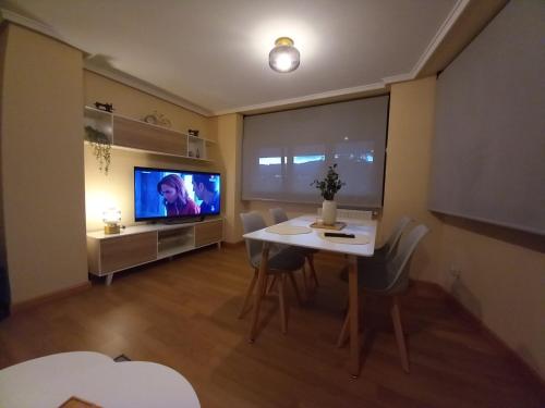 比利亚维西奥萨Apartamento Aurora的客厅配有餐桌和电视