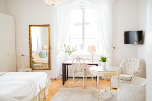 MauritsbergMauritzbergs Slott & Golf的白色卧室配有镜子和桌椅