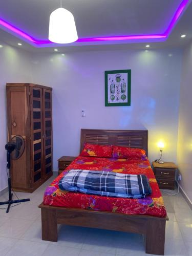 达喀尔La Belle Planque的一间卧室配有一张紫色天花板的床