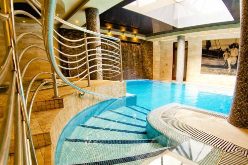 济夫努夫Hotel&Spa Stary Dziwnów basen swimming pool的一座带螺旋楼梯的游泳池