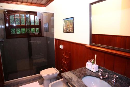 坎波斯杜若尔当Pousada Miraflores的浴室配有卫生间、盥洗盆和淋浴。