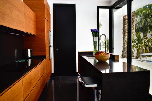 克萨达城Luxury Villa LAGUNA - Ciudad Quesada的厨房配有黑色台面和木制橱柜