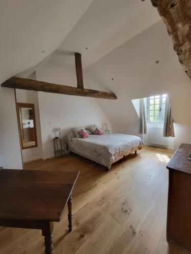 塔登Manoir de La Garaye - Suite Parentale的一间卧室配有一张床,铺有木地板