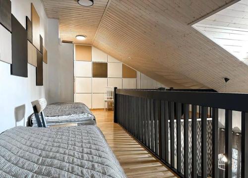 塔库沃里Yläkerran asunto parvekkeella ja saunalla的一间带两张床的卧室和楼梯