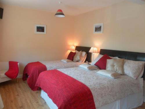 拉斯德拉姆莱特尔摩乡村房屋酒店的一间卧室配有两张红色和白色床单