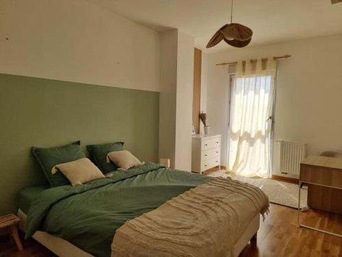 奥尔良Chez Sara et Joan : T2 hypercentre, cosy proximité gare的一间卧室设有一张绿色的床和一个窗户。