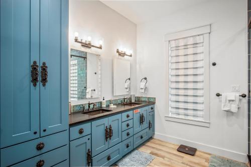 阿兰瑟斯港Luxury house with wet bar, outdoor shower, steps from Gulf的一间带两个盥洗盆和蓝色橱柜的浴室