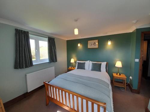 纽敦The Dolfor Inn的一间卧室设有一张大床和两个窗户。
