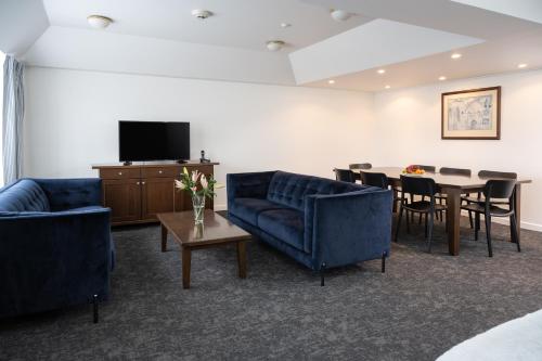 惠灵顿海湾广场酒店 的带沙发、桌子和电视的客厅