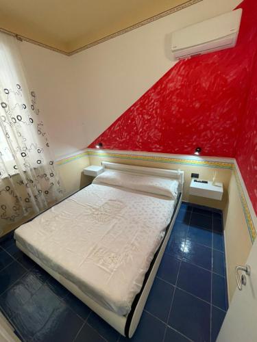 卡梅罗塔码头Dal Torrese的小房间设有一张床和红色的墙壁