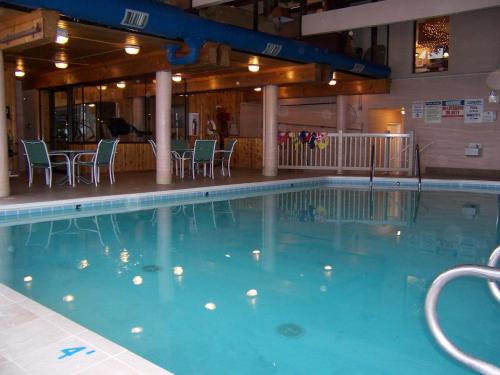 特拉弗斯城派恩斯蒂德珊瑚礁度假酒店的酒店的大型游泳池配有桌椅