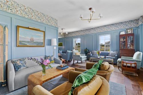 新肖雷汉姆Atlantic Inn的客厅设有蓝色的墙壁和沙发。