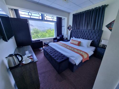 罕萨Royal's Villa by Premiere Inn, Hunza的酒店客房设有一张床和一个大窗户