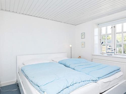 汉斯特霍尔姆Apartment Hanstholm的白色卧室配有蓝色床单