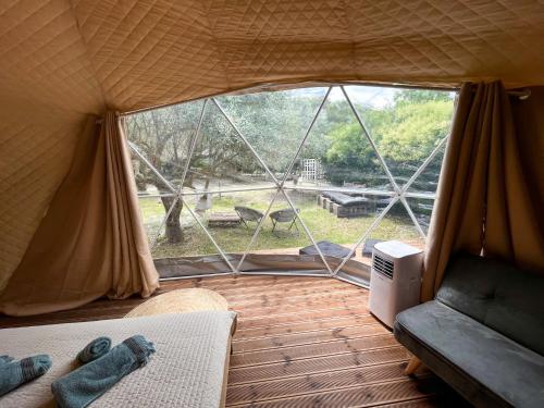 沃尼扎Manna Gea Glamping Domes的带大窗帐篷的客房