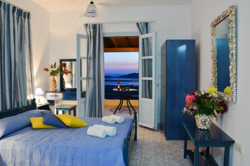 普拉蒂Hotel Dina - Ξενοδοχείο Ντινα的一间配备有蓝色床的卧室,享有海景