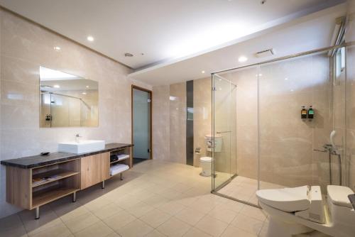 Mingjian翔禾大饭店的浴室配有卫生间、盥洗盆和淋浴。