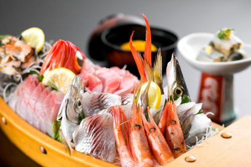 热海坎宜齐酒店的桌上的鱼和其他食物托盘