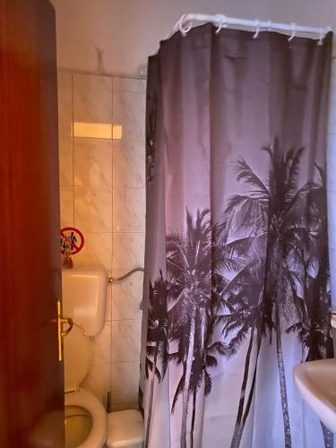 塞尔马Lydia Rooms的浴室设有棕榈树淋浴帘