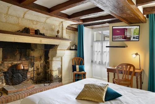 博蒙昂韦龙吉拉德尔庄园之家酒店的一间卧室配有一张床和一个壁炉