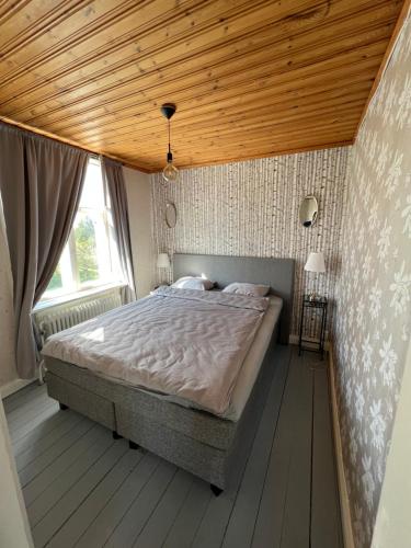阿尔维卡Arvika, Centralt的一间卧室设有一张带木制天花板的大床