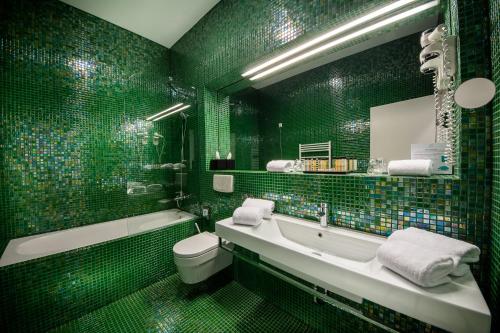 里姆斯克·托普利采Rimske Terme Resort - Hotel Sofijin dvor的绿色浴室设有浴缸、卫生间和水槽