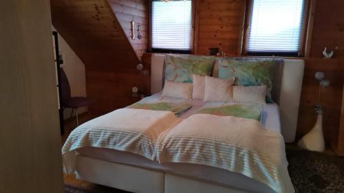 法克湖Ferienhaus Inselweg的卧室配有一张带白色床单和枕头的大床。
