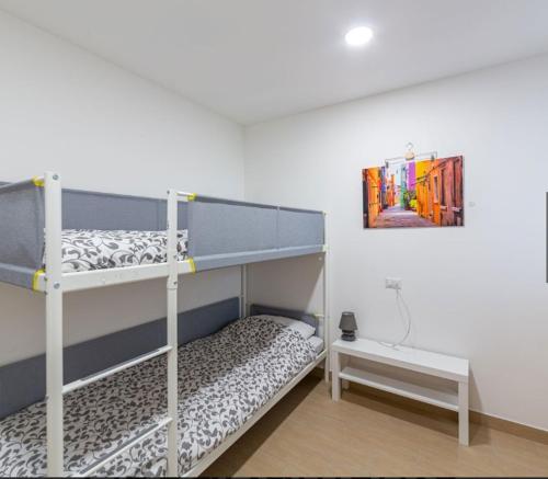 里米尼Miramare casa vacanze的一间卧室设有两张双层床和一张桌子