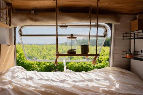 古尔Nuit insolite au milieu des vignes的一间卧室设有一张床和一个美景窗户。