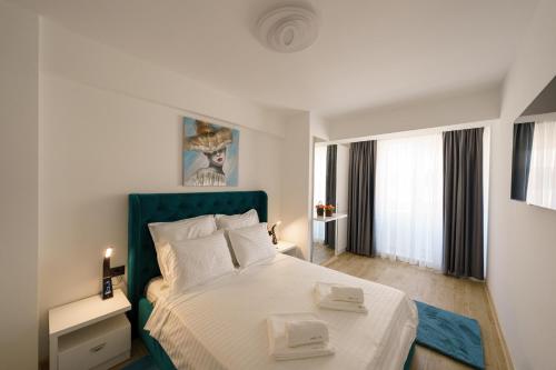 北马马亚-讷沃达里Castelana Infinity Beach Pool&Spa Mamaia Nord的一间卧室配有一张大床和蓝色床头板