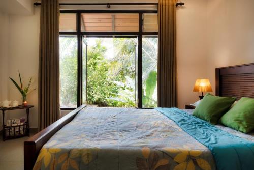 康提Kandy Tree Tops的一间卧室设有一张大床和大窗户
