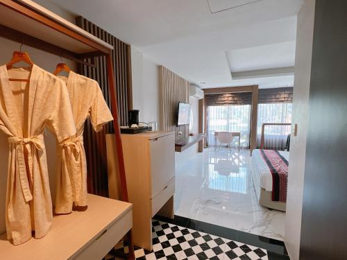 乌汶Ubonburi Hotel的酒店客房带床铺以及更衣室