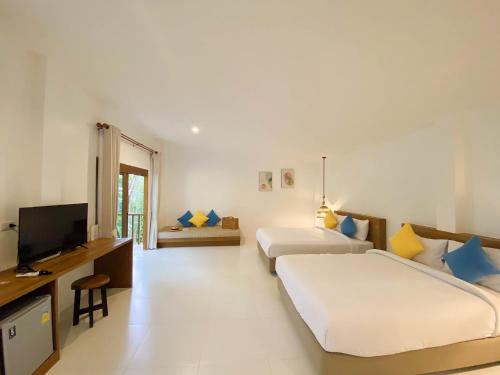 锡春Issara Beach Resort Beachfront的酒店客房设有两张床和电视。